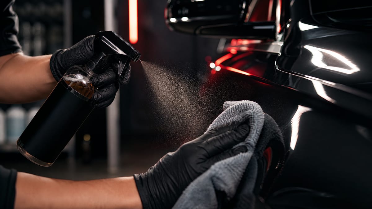A detailer applying protection to a car's exterior panel